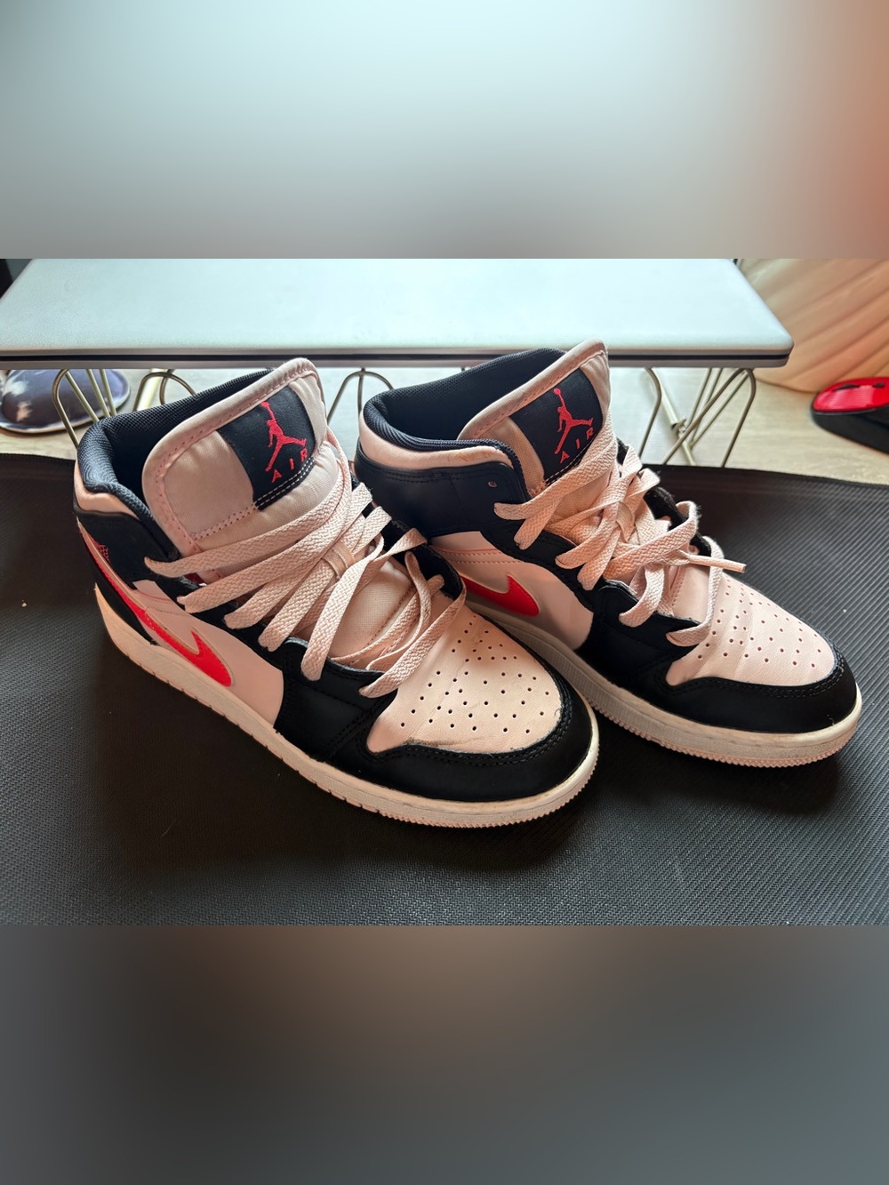 Nike Air Jordan 1 Mid Atmosphere Grade School sneakers in pink and black.